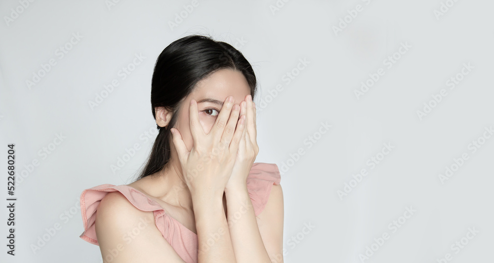 Asian beautiful woman covering face by both hand and peeking someone Asian beautiful woman covering face by both hand and peeking someone