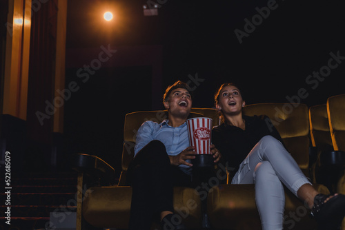 Young couples are excitedly watching movies in the cinema.