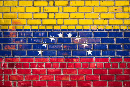 National flag of the Venezuela on a grunge brick background.