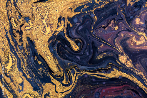 Luxury fluid art painting background. Spilled purple, blue and gold acrylic paint. Liquid marble pattern. Alcohol ink splash.
