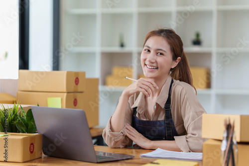 Attractive Asian SME business woman checking order at warehouse