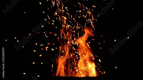 fiery sparks flying off the bright flames at night