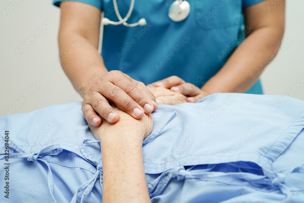 Doctor holding hands Asian elderly woman patient, help and care in hospital.