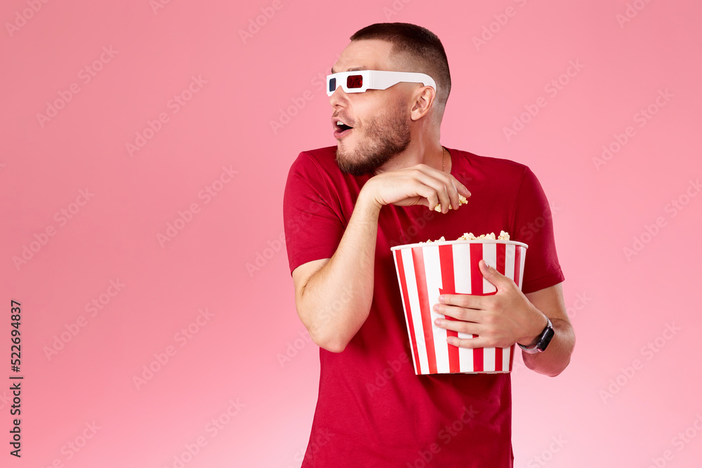 Young caucasian man in 3d glasses eating popcorn Young caucasian man in 3d glasses eating popcorn