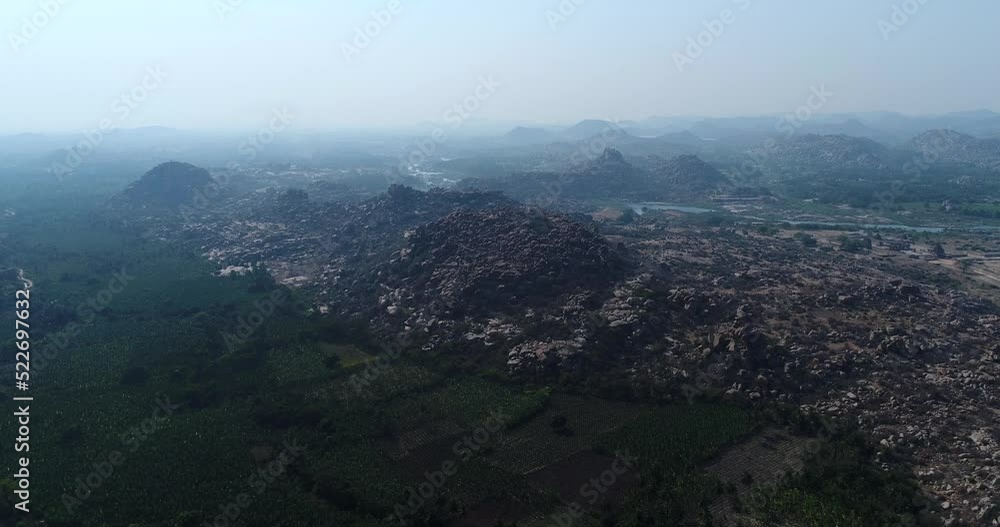 Aerial shot of rocky landscape with bouldery hills, fields in between Aerial shot of rocky landscape with bouldery hills, fields in between