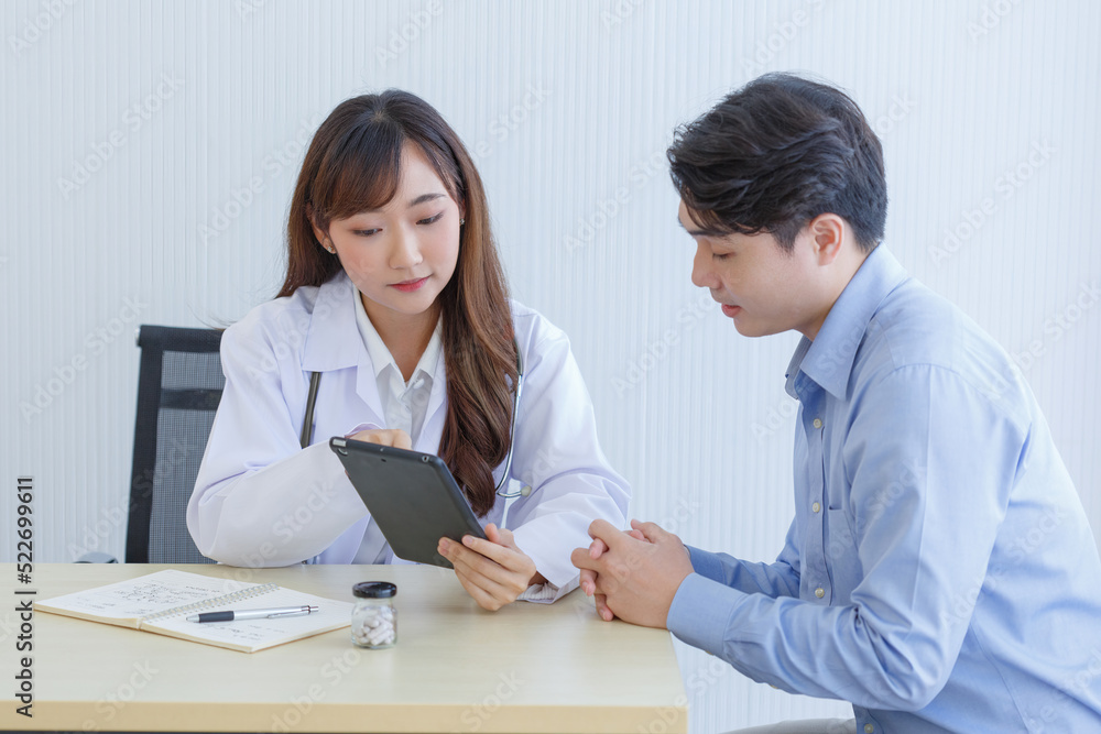Female doctor and young male patient while consult and .explain. Doctor and patient sitting together at table in examination room. Female doctor and young male patient while consult and .explain. Doctor and patient sitting together at table in examination room.