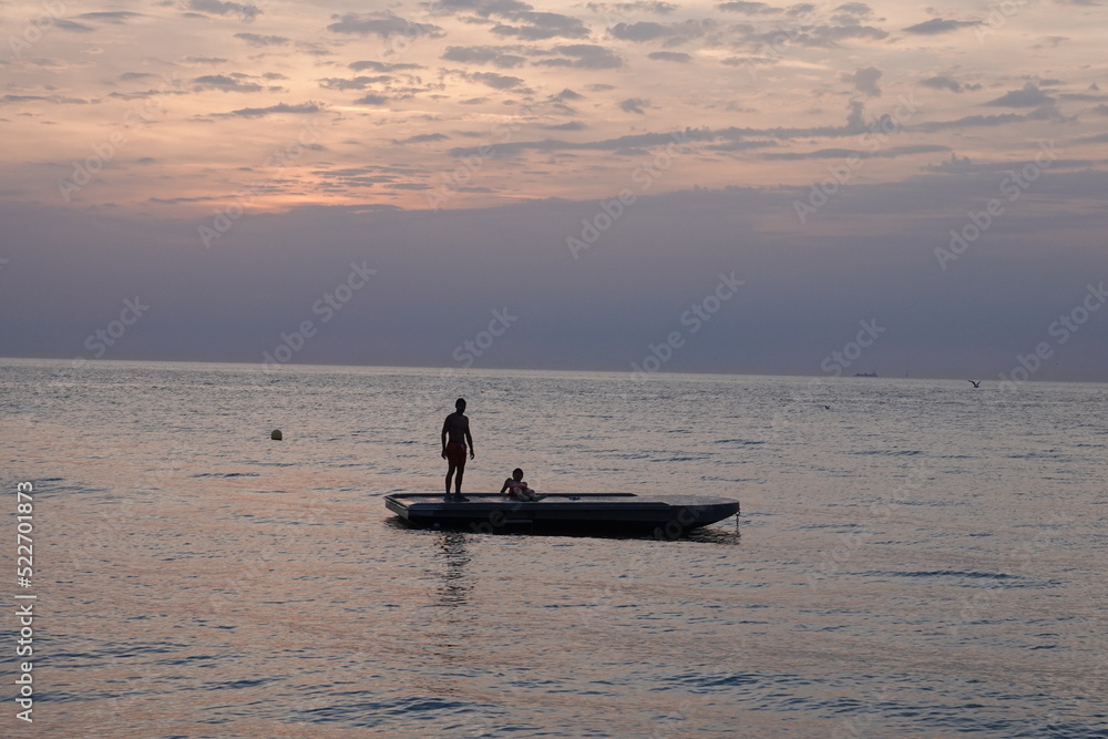 Bain de mer devant un coucher de soleil