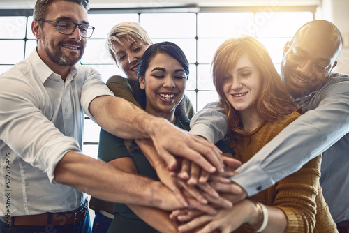 Hands in a huddle for teamwork, working together and unity between a business team of happy colleagues. A group of motivated and smiling creative designers with a mindset of support and collaboration