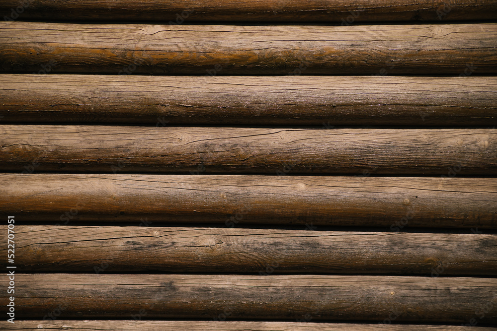 Wooden logs walls of the house. Texture of brown logs. Rustic background. Horizontally arranged boards. Wooden logs walls of the house. Texture of brown logs. Rustic background. Horizontally arranged boards.