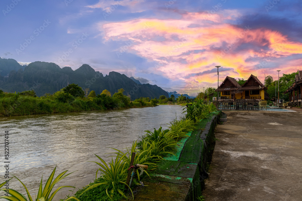 Fototapeta premium Vang Vieng Laos a beautiful city on the river with huge rising mountains and slow flowing river. 