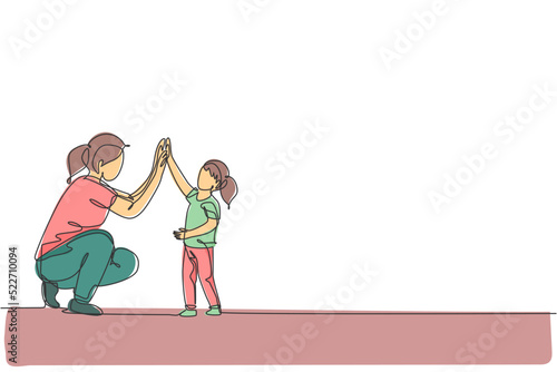 One continuous line drawing of young happy mom giving high five to daughter, celebrate her success for school achievement. Family parenting concept. Dynamic single line draw design vector illustration