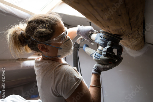 Photos Woman carpenter using electric sander for wood