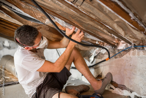 Worker with glasses and protective mask isolating the ceiling