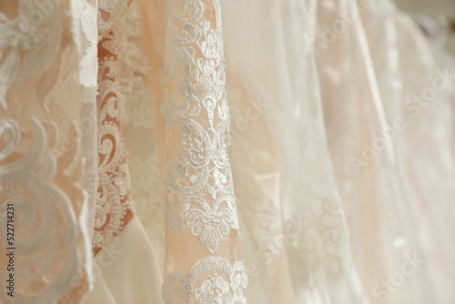 Different wedding dresses on hangers, closeup view