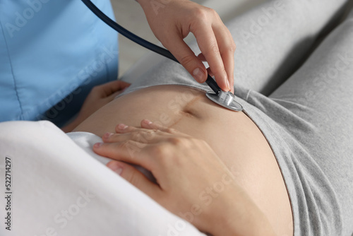Doctor examining pregnant woman in hospital, closeup