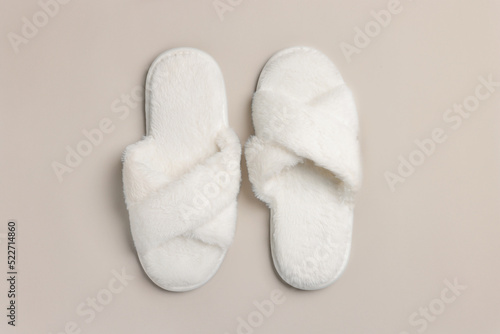 Pair of soft fluffy slippers on light grey background, top view