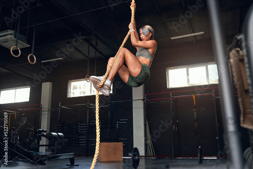 Woman Performing Rope Climbs at the Gym. Performance Agility Biceps Strong Energetic Athletics Healthy Powerful Determination Concept. Fitness and Sport 