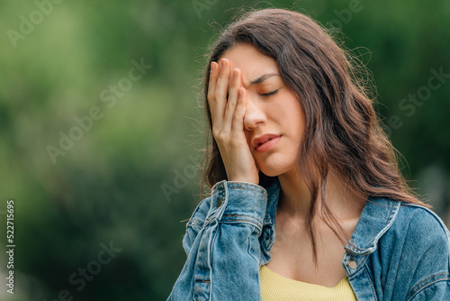 girl in the street with a headache expression