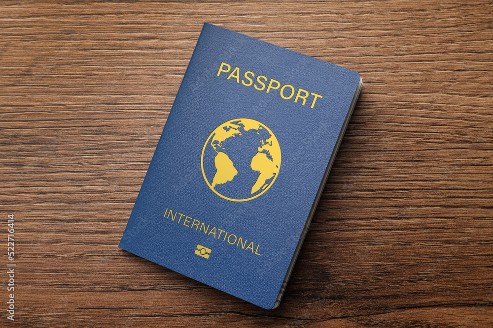 Blue international passport on wooden table, top view Blue international passport on wooden table, top view