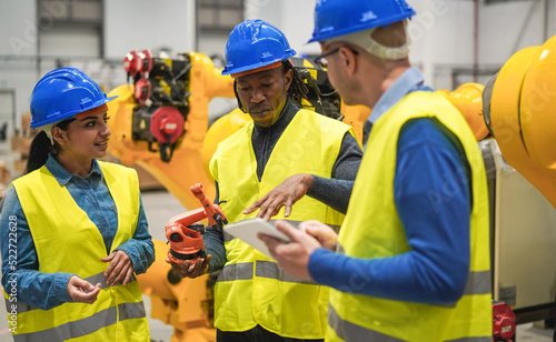 Multiracial engineers working inside robotic factory - Soft focus on african man face