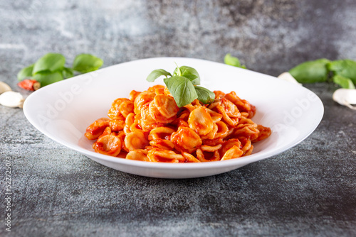 Orecchiette with fresh tomato sauce and basil. Typical dish of Italian Cuisine. Vegetarian food, quick lunch.
