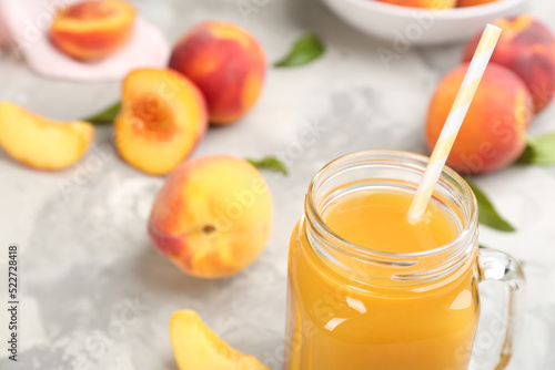 Natural peach juice and fresh fruits on grey table, closeup