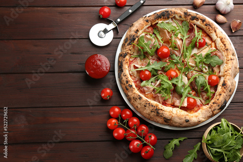 Tasty pizza with meat and arugula on wooden table, flat lay. Space for text