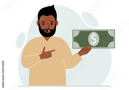 A man holds a large paper bill in his hand. The concept of income, expense, earning or spending money.