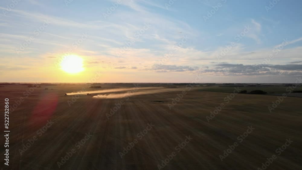 The dusty process of harvesting barley by two combines viewed from above. Wide angle sunset drone footage The dusty process of harvesting barley by two combines viewed from above. Wide angle sunset drone footage