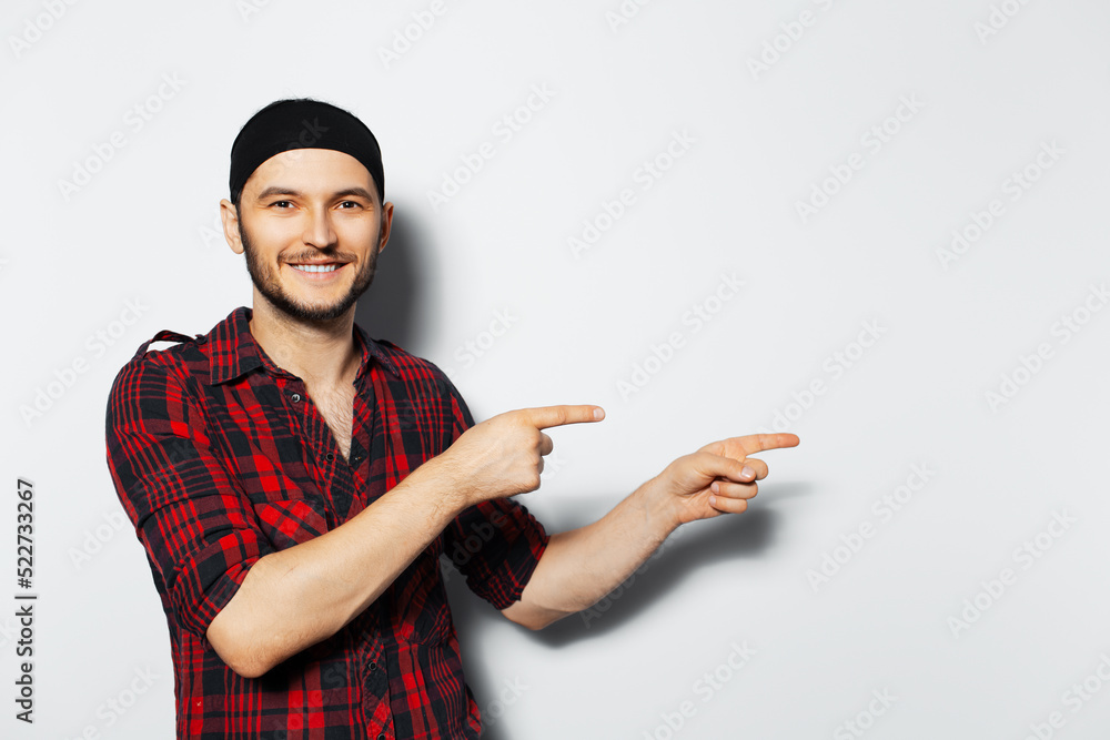Studio portrait of young smiling guy, pointing to the left. Copy space idea. Studio portrait of young smiling guy, pointing to the left. Copy space idea.