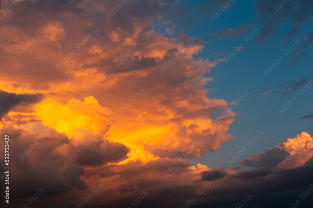 Beautiful landscape of sunset with dark colourful fluffy clouds. Natural background.