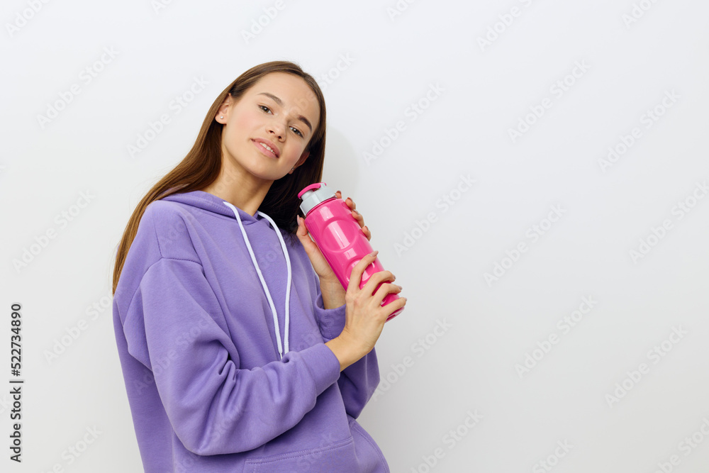 a happy woman stands on a white background in a purple suit hugs a pink bottle with both hands and joyfully presents it to her face a happy woman stands on a white background in a purple suit hugs a pink bottle with both hands and joyfully presents it to her face