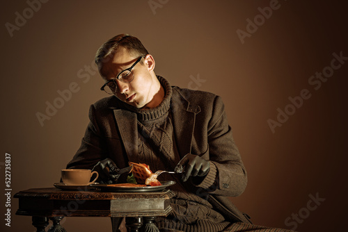 Retro style portrait of young man, writer and traveler wearing vintage style clothes isolated over dark brown background. Business, art, fashion concept