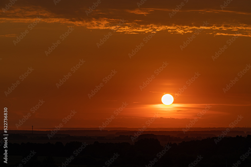 orange sunset in the summer on the background of the field orange sunset in the summer on the background of the field
