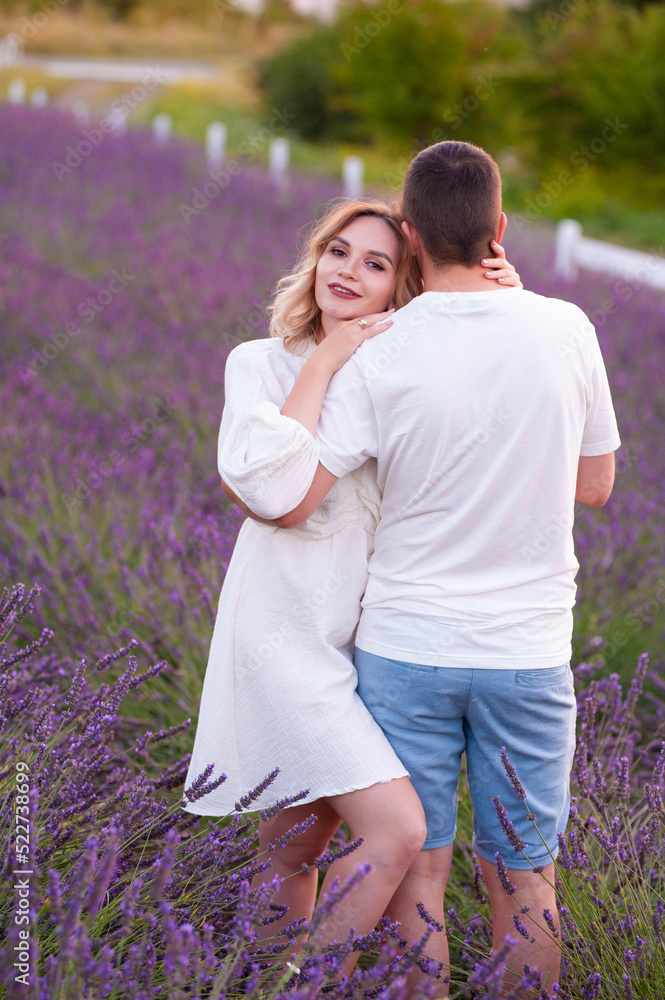 Fototapeta premium Young couple in love bride and groom, wedding day in summer. Enjoy a moment of happiness and love in a lavender field.