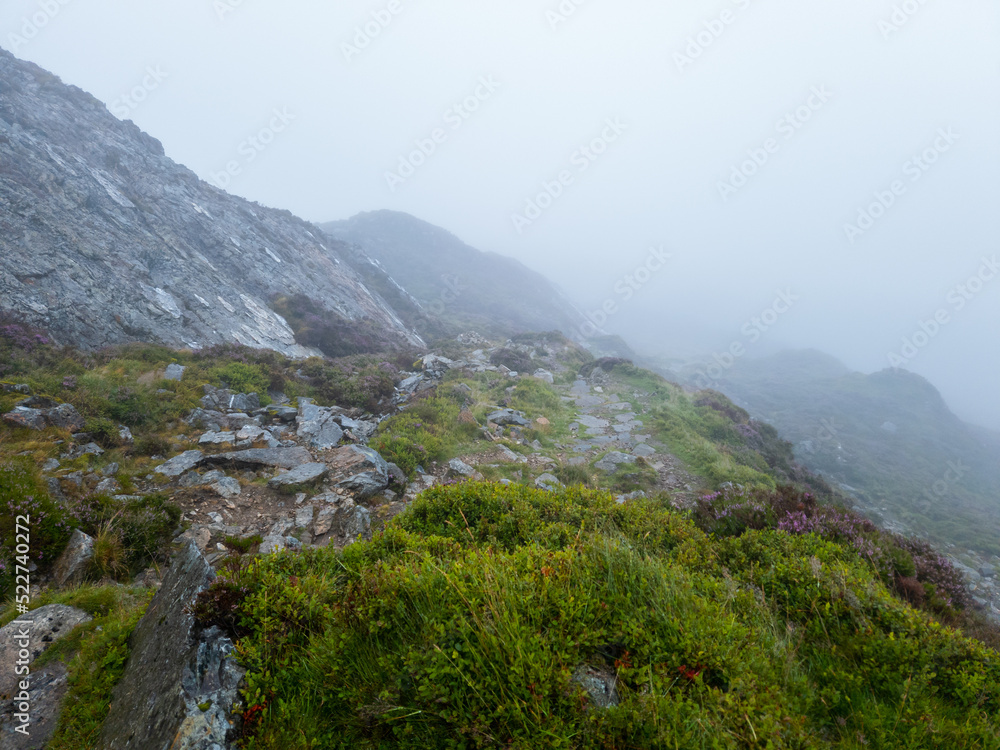 Naklejka premium National Park Lake District, Helvellyn Hills, view while climbing Lake Thirlmere and Red Tarm, crossing Striding Edge and Swirral Edge during fog, 2022.