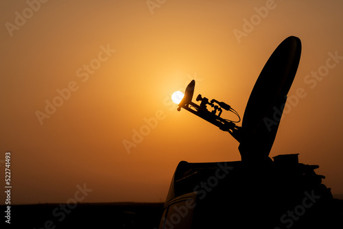 Фотография Live broadcast satellite antenna silhouette on an impressive summer sunset background