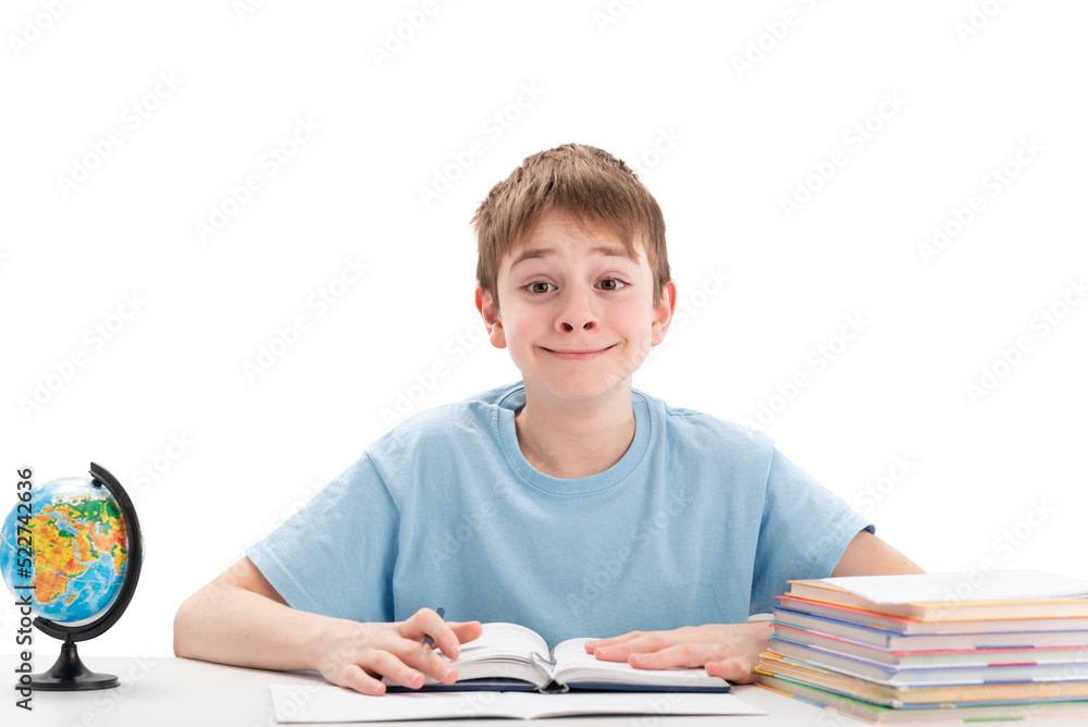 Smiling teenage boy sits at table with stack of notebooks doing homework. Education abroad concept. International education. Smiling teenage boy sits at table with stack of notebooks doing homework. Education abroad concept. International education.