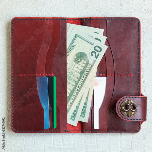 Open red leather clutch with money and credit cards