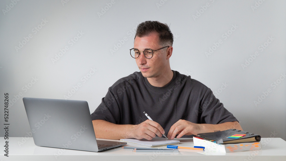 Male student studying with a laptop, recording a lecture Male student studying with a laptop, recording a lecture