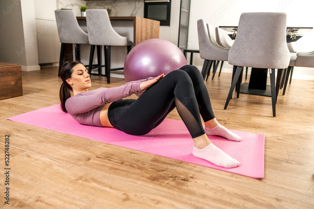Obraz premium Attractive woman exercising at home