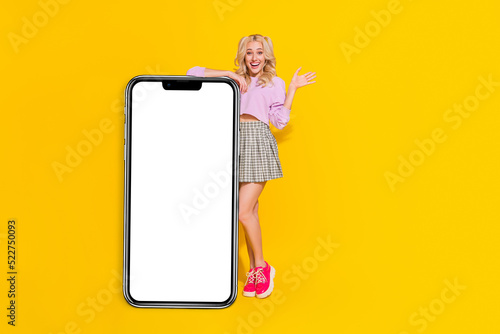 Full body photo of funny positive girl raise hand palm empty space blank isolated on yellow color background