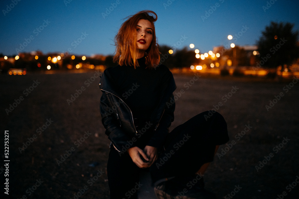Portrait of a beautiful young woman with red air at the sunset
