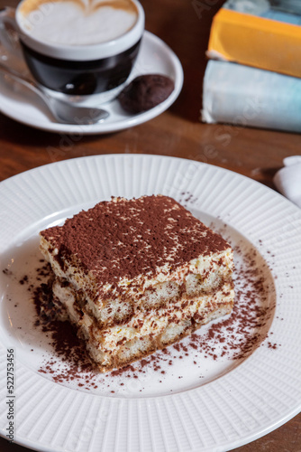 Tiramisu in a plate with a cup of coffee