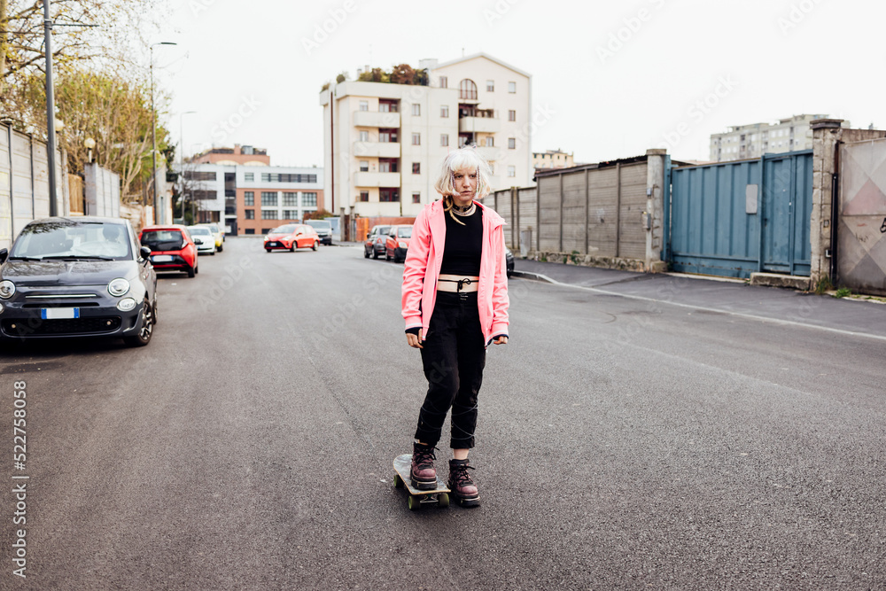 rebel alternative young woman outdoors riding skate