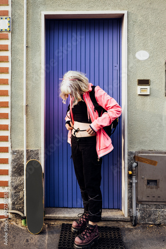 Young rebel gender fluid skater woman posing outdoors