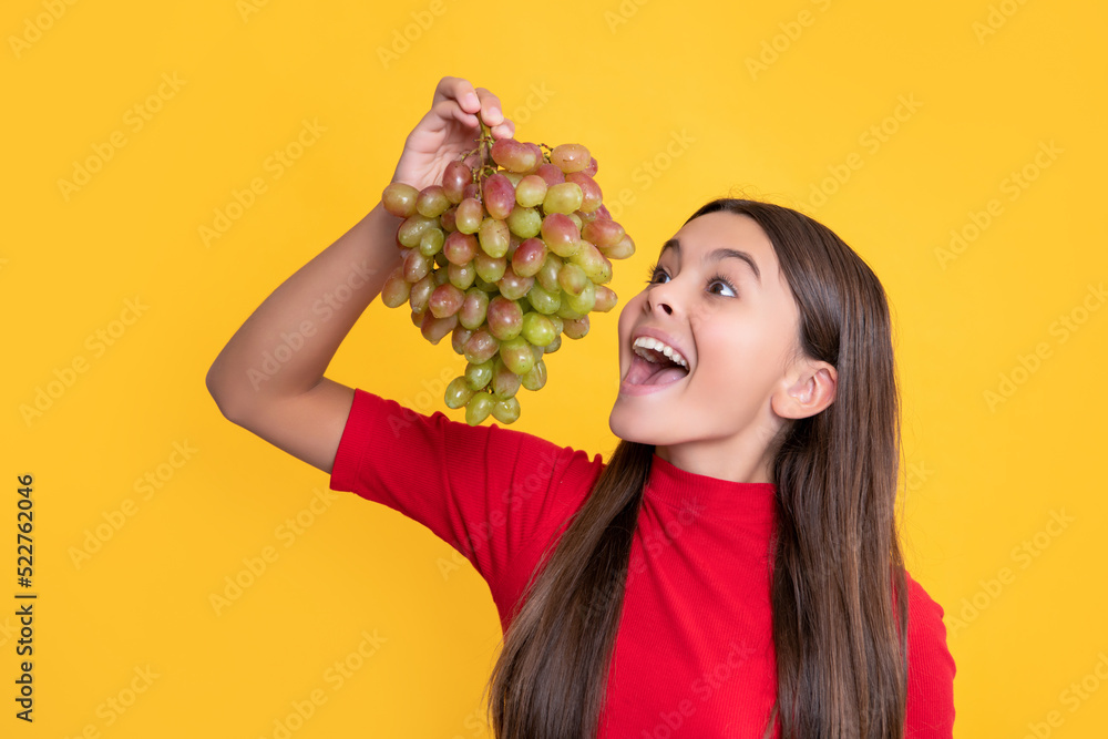 © be free - amazed child eat bunch of grapes on yellow background © be free - amazed child eat bunch of grapes on yellow background