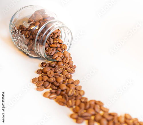 Spilled coffee beans in jar