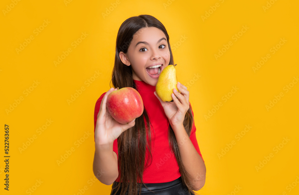 cheerful amazed child hold fresh apple and pear on yellow background. selective focus cheerful amazed child hold fresh apple and pear on yellow background. selective focus