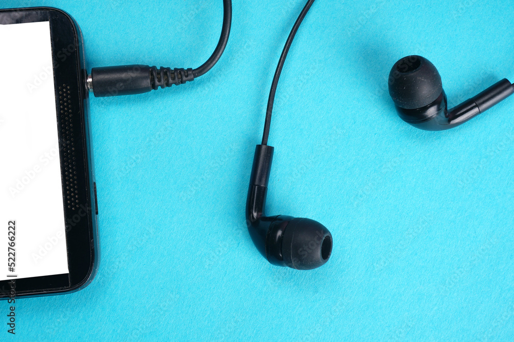 Top view of Mobile phone with headphones isolated on colorful background, Listen to music. Space for text Top view of Mobile phone with headphones isolated on colorful background, Listen to music. Space for text